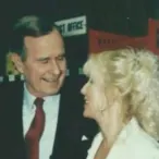 George bush A woman with blonde hair smiles while talking to a man in a suit and red tie in an indoor setting. This image captures a moment of connection, reflecting themes of nonprofit leadership and advocacy related to Linda Smith.| Linda’s Life – Linda Smith