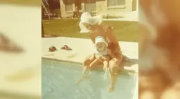 Capture A woman in a sun hat sits by a pool, holding a baby on her lap. The scene reflects a moment of joy and warmth, embodying themes of advocacy and Down syndrome awareness linked to Linda Smith's inspirational storytelling.| Linda’s Life – Linda Smith