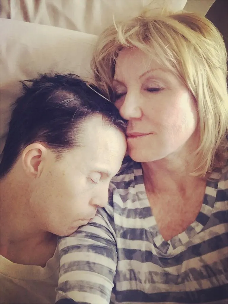 A woman gently embraces a young man with Down syndrome, both peacefully resting. This image reflects the compassionate advocacy and inspirational storytelling of disability advocate Linda Smith, highlighting her personal journey and dedication.| Linda’s Life – Linda Smith